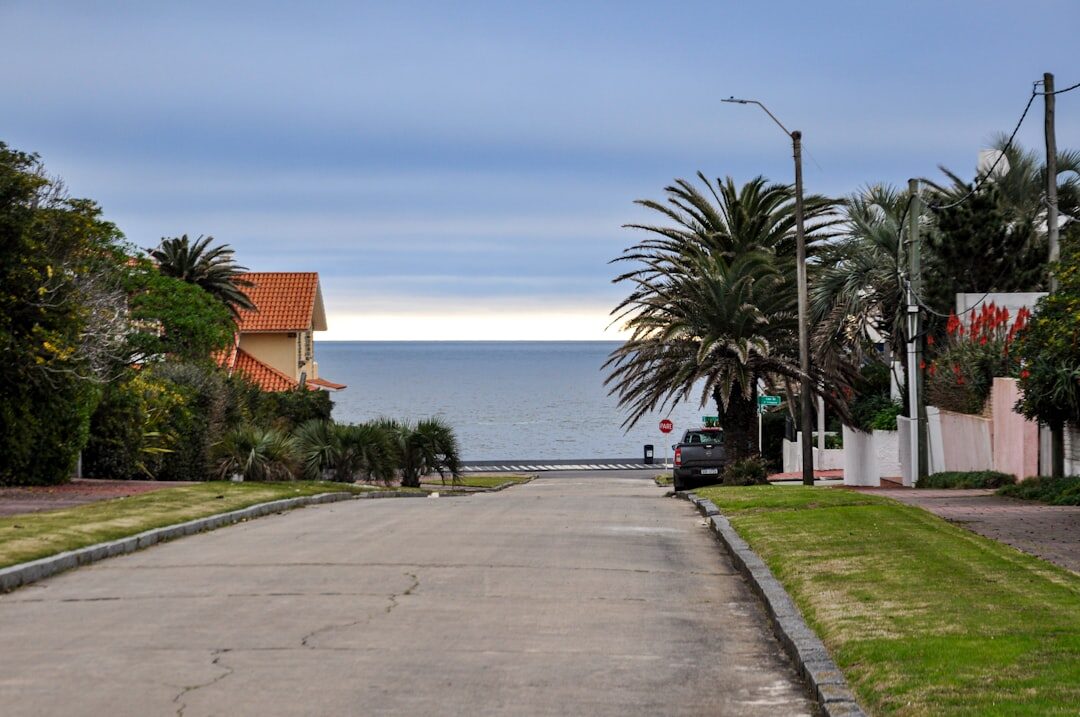 Elegant sedan driving along a coastal road in Punta del Este at golden hour